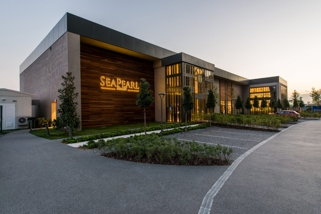 Seapearl Ataköy satış ofisi — akşam ışığında ahşap kaplamalı cephe ve aydınlatmalı SEA PEARL tabelası