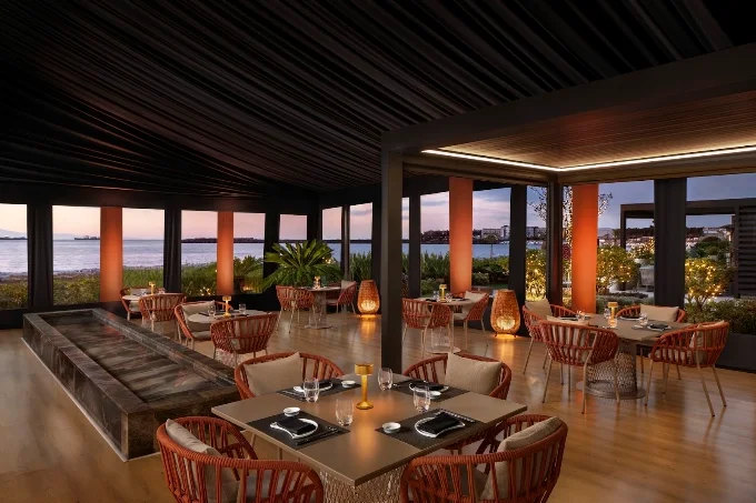 Akira Back Sea Pearl Marriott — gün batımında teras yemek alanı ve deniz manzarası