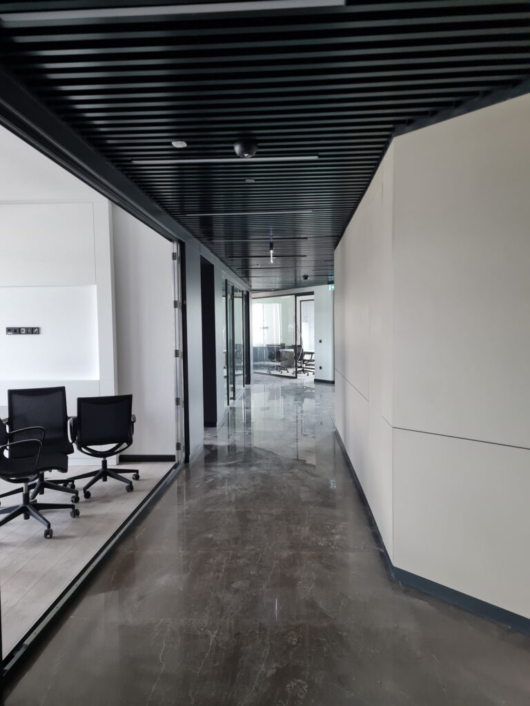Fimar Holding merkez ofis — koridor ve cam bölmeli çalışma birimleri